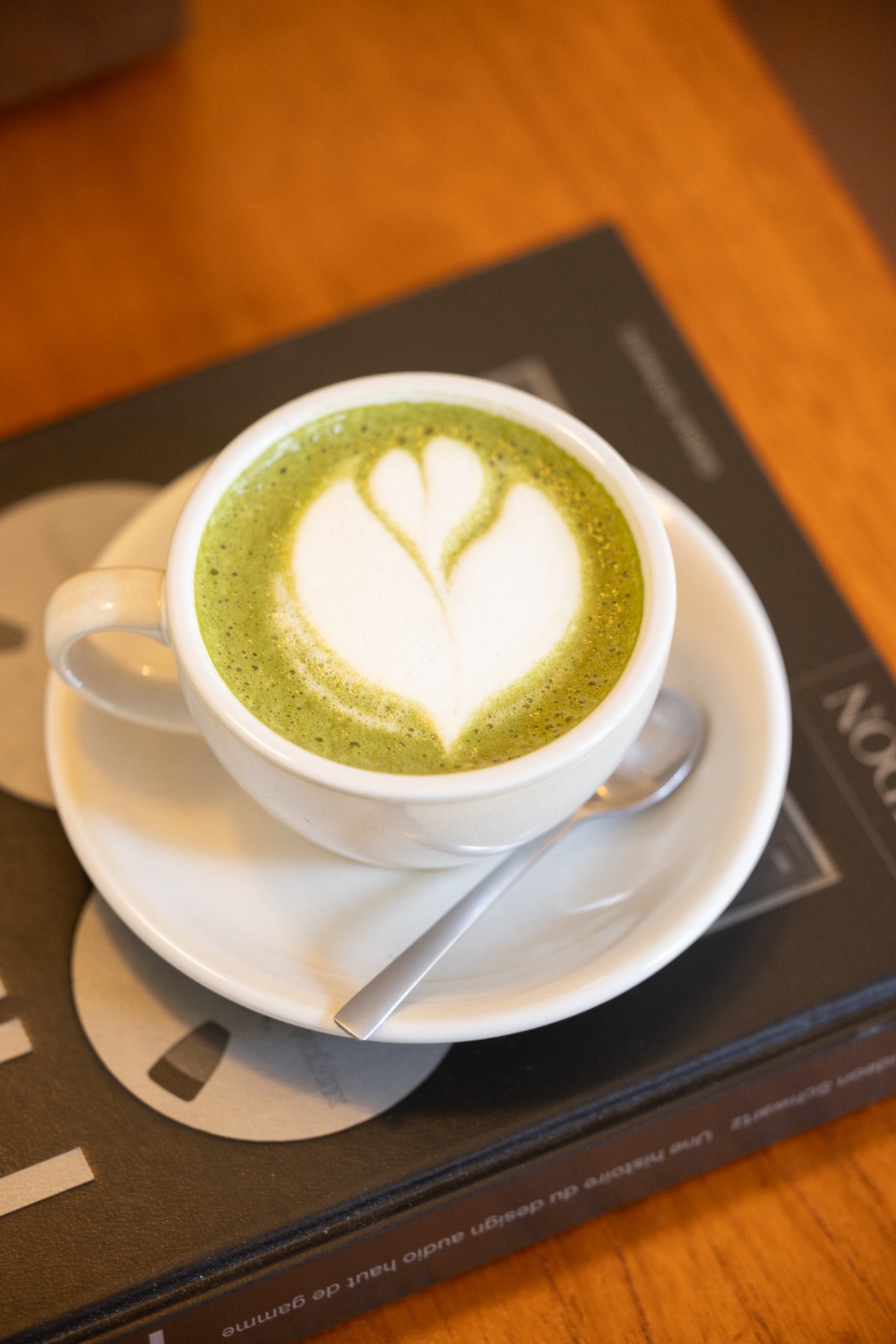 Matcha latte posé sur un livre de design audio